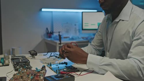 Black Engineer lötet Leiterplatte im Labor