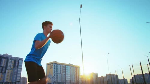 Young Adult Playing Basketball on Urban Court