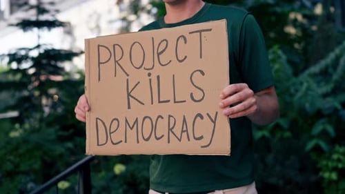 Gros plan : un manifestant avec une pancarte à la main, campagne présidentielle, corruption
