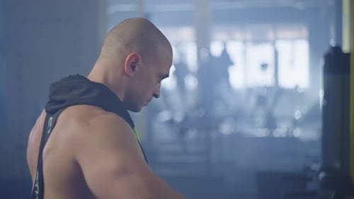 Man Shoulder Workout with Dumbbells in Gym