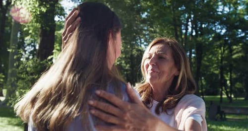 Affectionate Senior Woman Embracing Younger Woman in Park