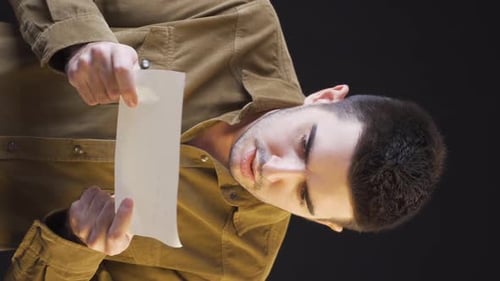 Vertical video of Psychologically troubled man is tearing documents.