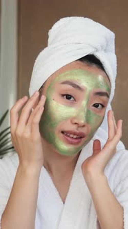 Woman Applying Green Face Mask