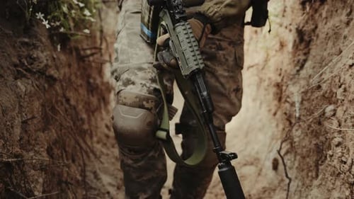 Armed Soldier in Tactical Gear Closeup of a Soldier in Camouflage Holding a Rifle