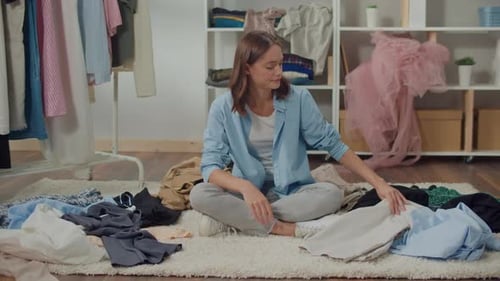 Young Woman Sorting Clothes in Her Room