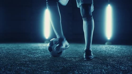 Football Player Practicing Dribbling and Dummy By Feet and Ball on Field Closeup View