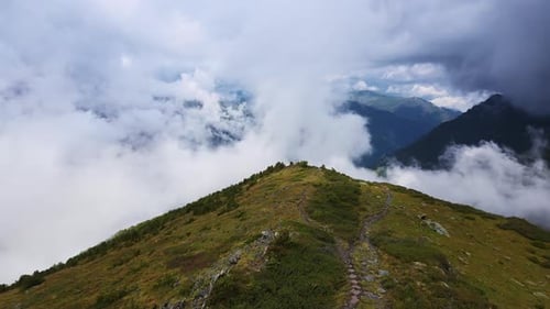 A Charming View of the Green Mountainside and Cloudfilled Valley