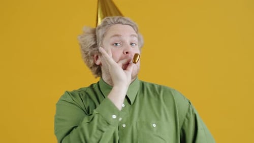Blond Man Celebrates Birthday with Party Horn