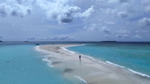 A model walks on the sand on the island