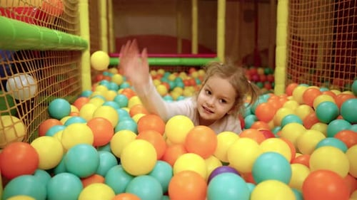 Aire de jeux avec piscine à balles intérieure, joyeuse et souriante, petite fille mignonne qui s'amuse au centre de jeux intérieur
