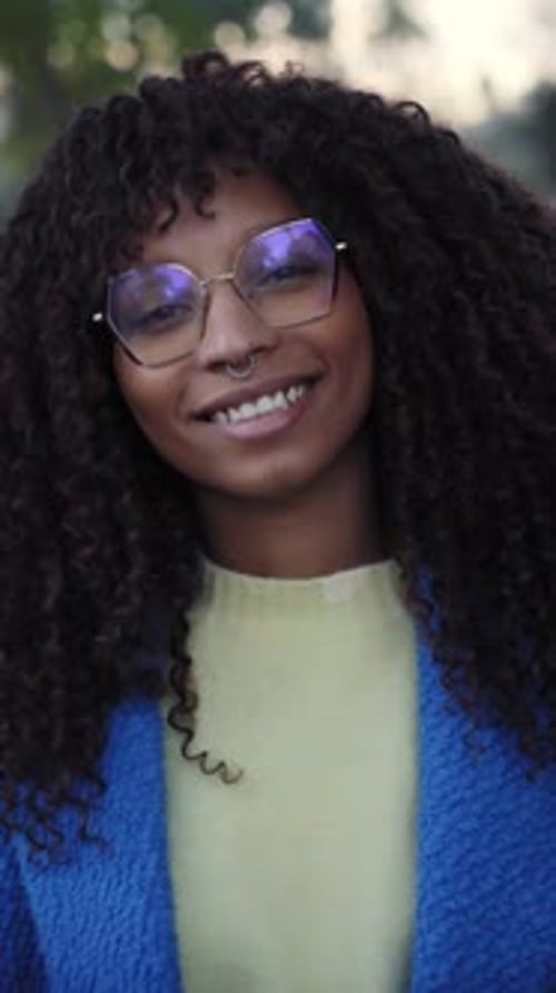 Portrait of Smiling Woman with Curly Hair and Glasses