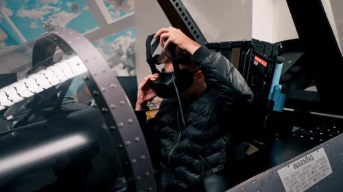 a guy sits in a flight simulator of a military plane before the start of the flight puts on virtual