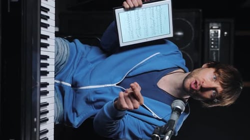 Musician Plays Keyboard, Reads Tablet, Sings Song