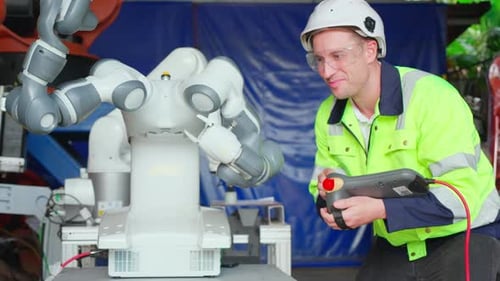 Junger Ingenieur überprüft und gewartet die Technologie der Maschinenroboter in der Fabrik.