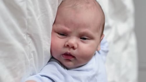 Adorable Infant Lying on White Blanket