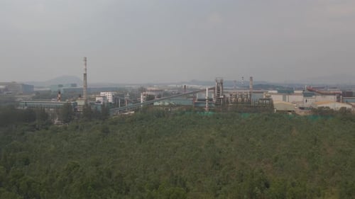 Aerial Tracking view along Factory infrastructure on countryside landscape