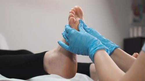 Close Up Masseur Doing Massage of Feet at Beauty Salon to Woman