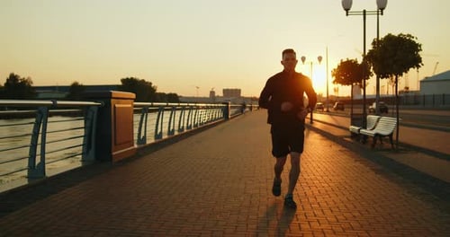 Young Athlete Jogging on a City Street at Sunset