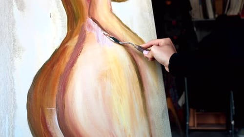 Beautiful woman painting with watercolors at an art gallery workshop