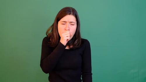 Young Adult Woman Coughing Against Green Screen