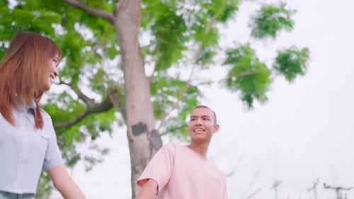 Romantic Couple Holding Hands Walking Through Park