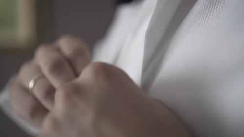 Man Buttons White Shirt in a Close Up Shot