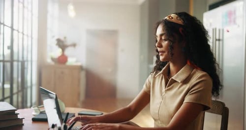 Woman Working on Laptop at Home in Sunlight