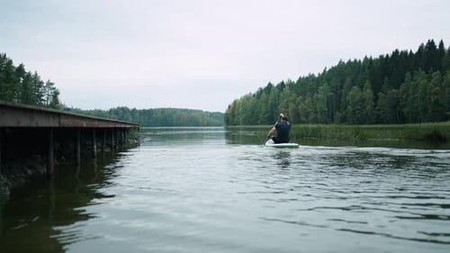 Mann schwimmt auf einem Stehpaddelbrett im Fluss, Sportaktivitäten und Wochenendtrip für einen gesunden Lebensstil