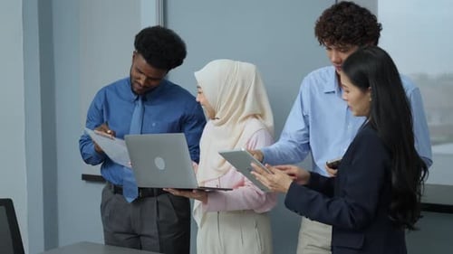 Diverse Team Collaborates on Project in Modern Office