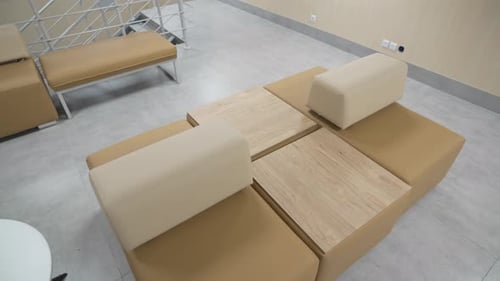 Poufs with Soft Backs Near Smooth Wooden Tables in Lounge