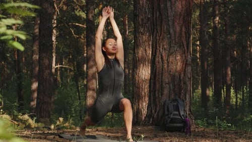 Woman Practices Yoga in a Sunny Forest