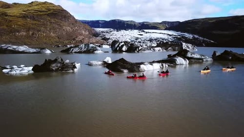 Aerial landscape view of people kayaking near Sólheimajökull glacier, Iceland, on a sunny day