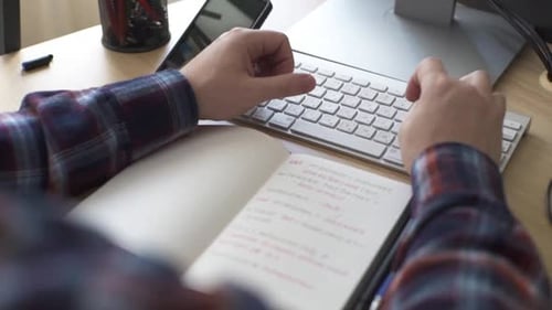 Ein behinderter Arbeiter, der im Rollstuhl sitzt, arbeitet an einem Computer