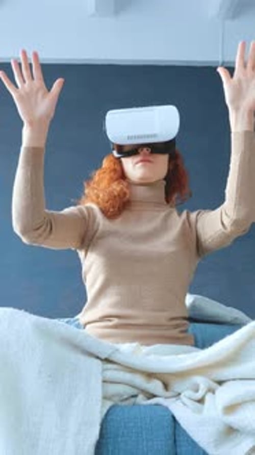 Woman Wearing VR Headset Sitting on Sofa