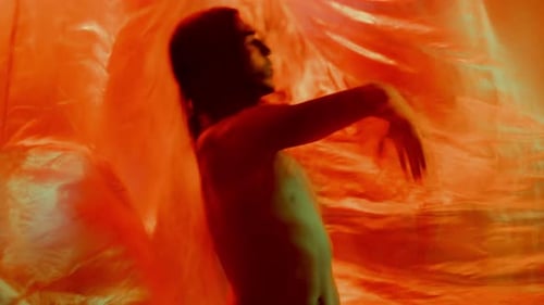 Dancer Performing Dramatic Dance in Colorfully Lit Studio