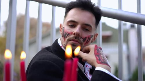 Man with Horror Makeup Posing with Candles