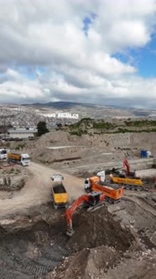 Vertical Aerial View of Excavators Loading Trucks at Construction Site