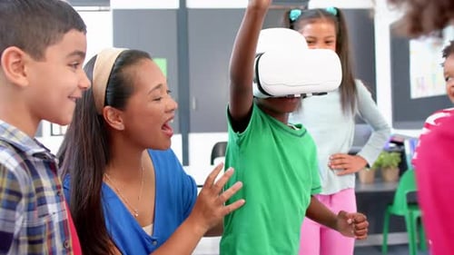 In school, children using VR headset with teacher guiding them in classroom