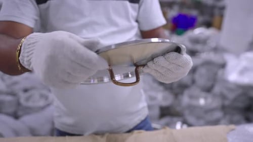 Shining and packing steel pans in a cookware factory