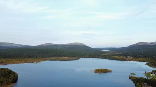 Aerial descends to picturesque countryside lake in flat boreal forest