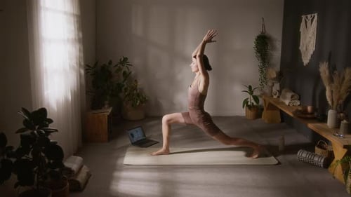 Girl Learning Virabhadrasana Sequence while Exercising to Yoga Video