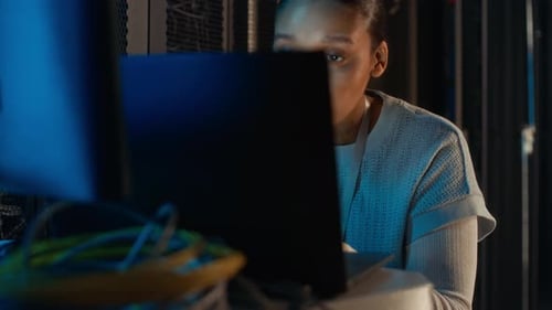 Female Programmer Working on Laptop in Data Center