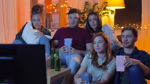 Friends Watch TV with Popcorn and Beer Indoors