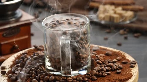 Coffee beans in mug with smoke on wood