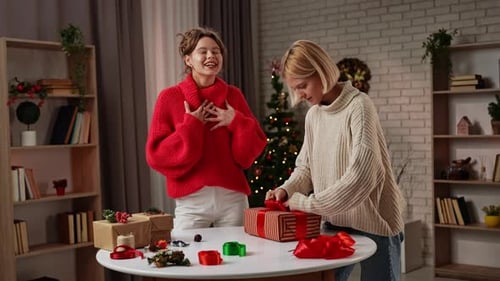 Women Wrapping Christmas Presents Together Indoors