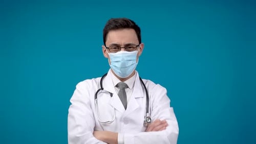 Male Doctor in Mask Looking at Camera in Studio