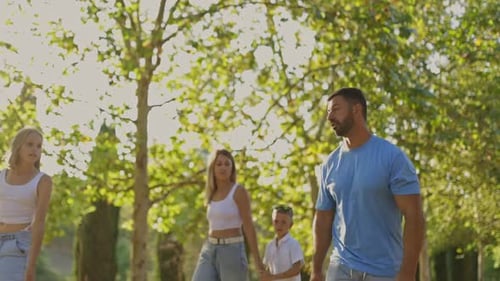 Happy Family Walking in Park on Sunny Day