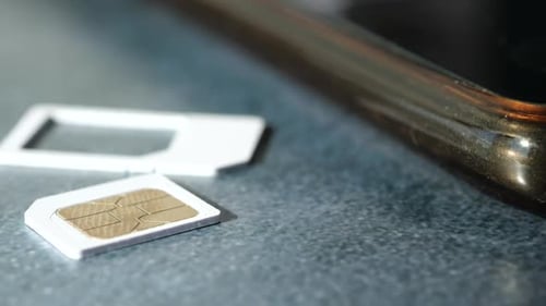 Einlegen einer SIM-Karte in ein Smartphone am Schreibtisch