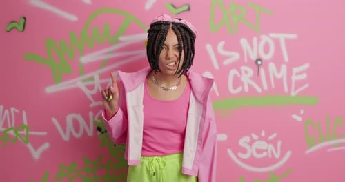 Stylish young woman posing in front of graffiti