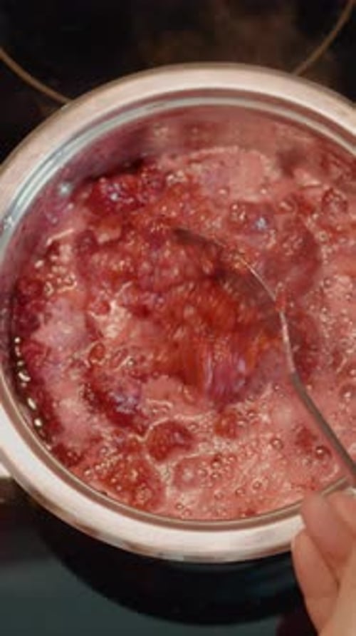 Cooking Raspberry Jam in a Metal Pot on Stove